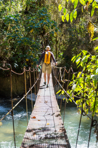man crossing bridge in costa rica