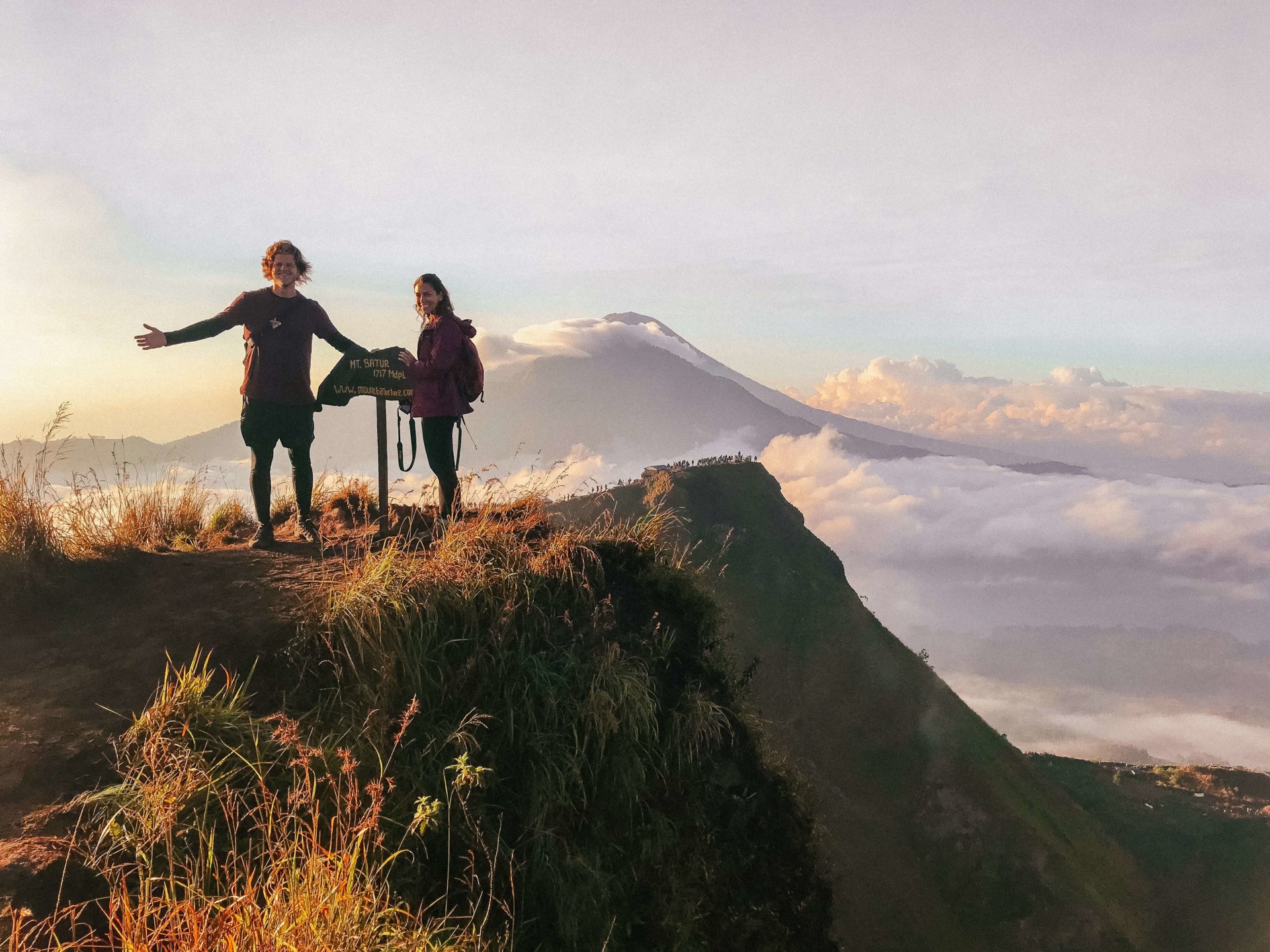 Double Occupancy standing on Mount Batur during sunrise