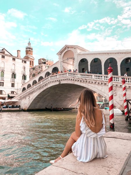 woman sitting next to bridge in Venice