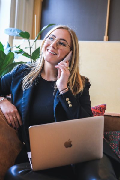 woman on her cellphone with laptop in lap