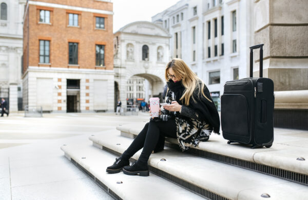 woman sitting on steps next to luggage