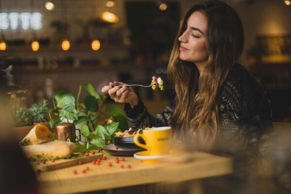 woman enjoying a healthy meal inside a cozy lit restaurant 