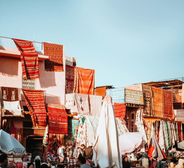 city in the middle east with rugs for sale on the side of buildings