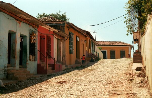 neighborhood street in cuba with person walking on the side