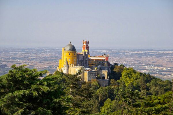 yellow castle in Portugal overlooking land from afar