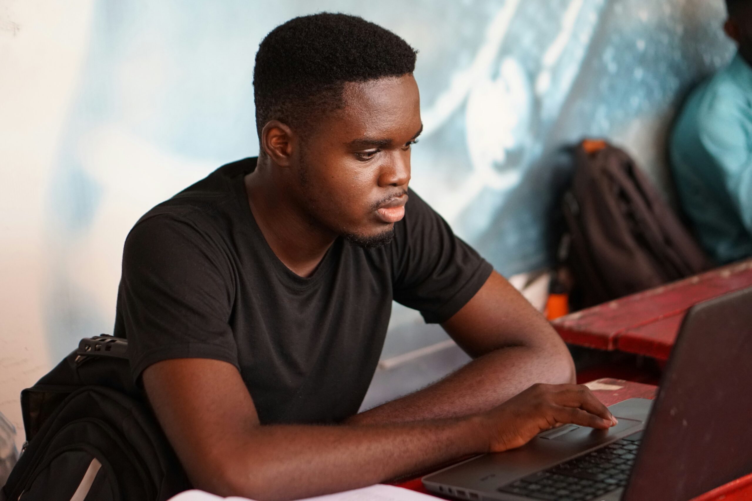 black man using a laptop sitting at a table