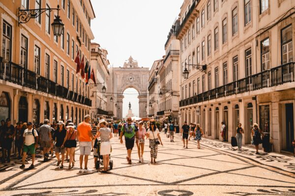 city center with beautiful buildings with old architecture and people walking down promenade in Portugal