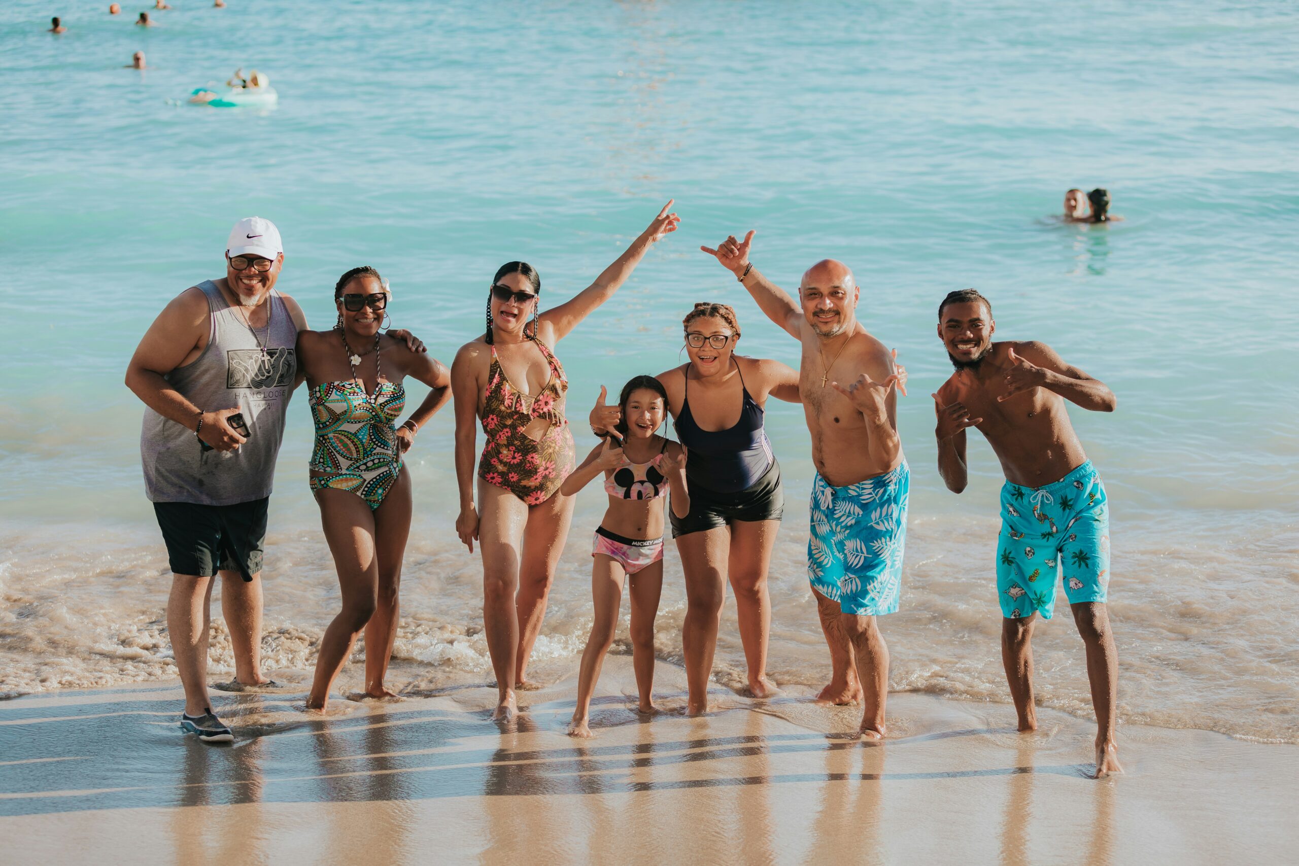 family posing for a picture on the beach in swimsuits