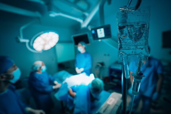 operating room with doctors and patient and iv fluids