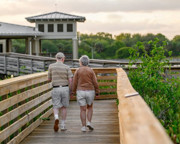 couple walking down a boardwalk bridge